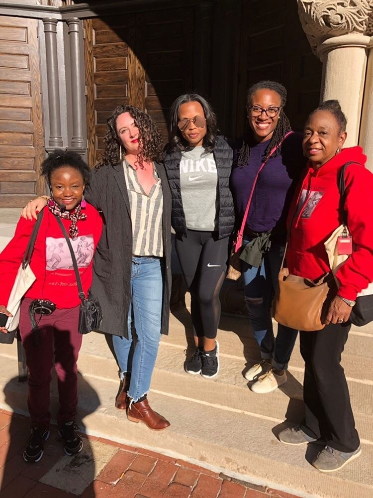 Black history tour group posing in front of historical site.