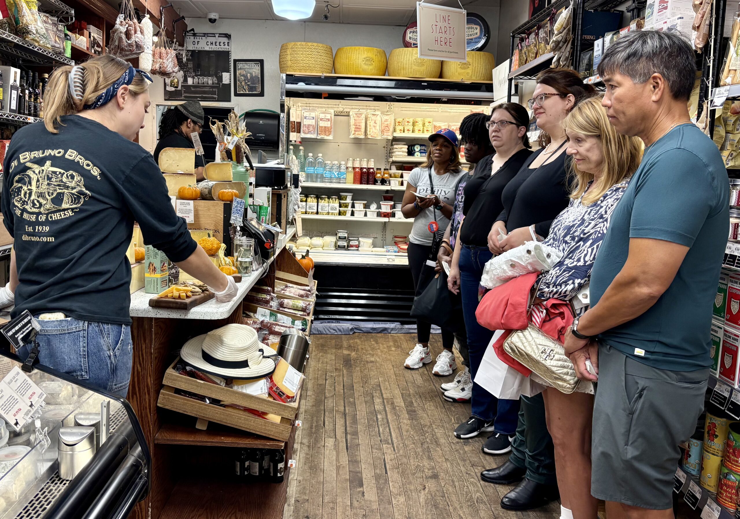 Interior image of a group of Phambassadors inside the DiBruno Bros on 9th Street.