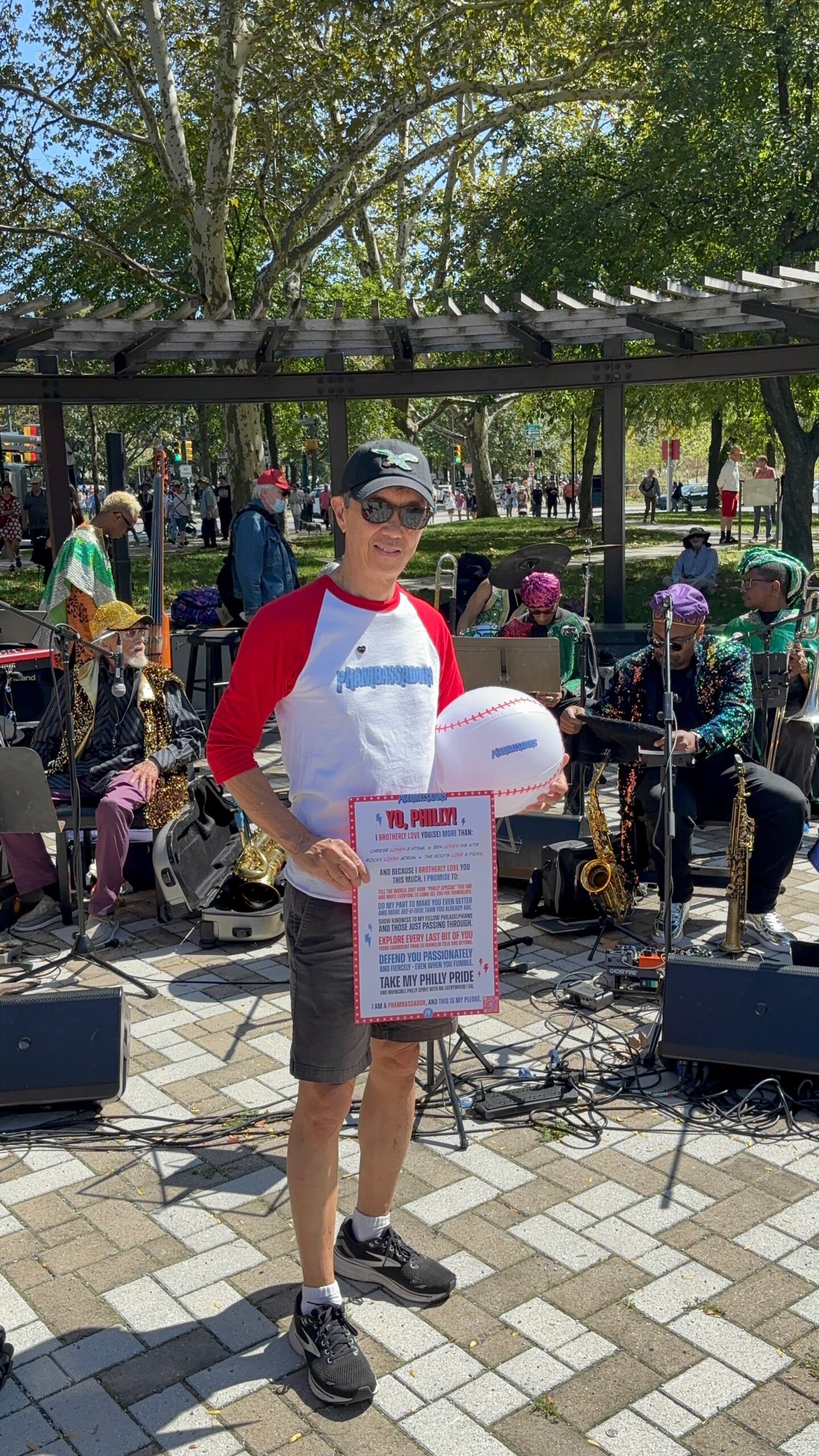 Andy Toy holding a copy of the Phambassador pledge outside of Calder Gardens