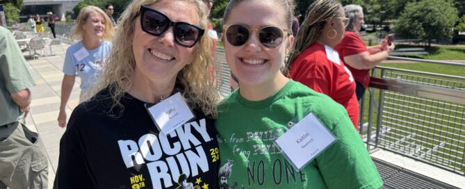 Two white women, Kathy and Kaitlin Nasevich, wearing their Philly gear at Pham Camp